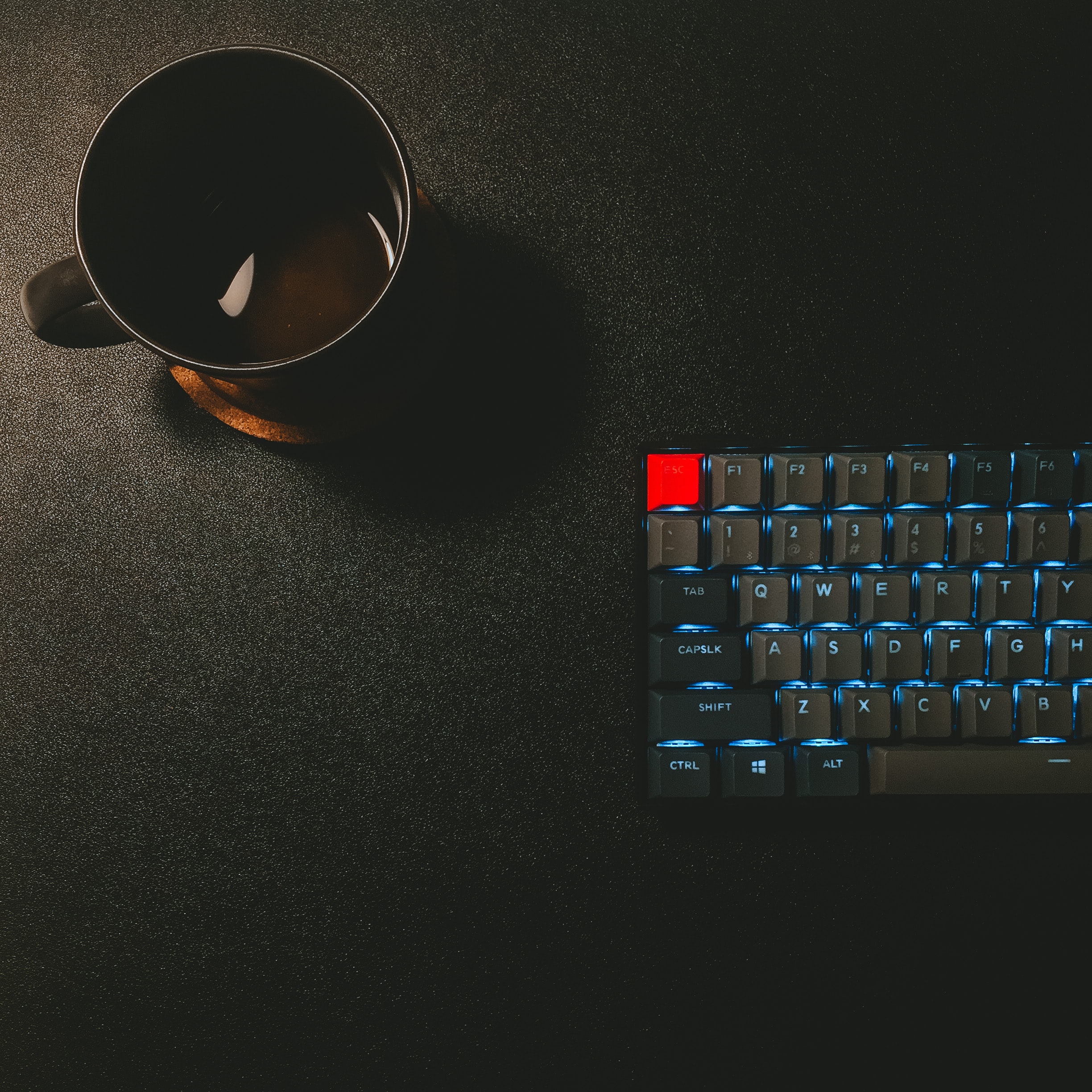 Image of a lit up keyboard with a coffee cup.